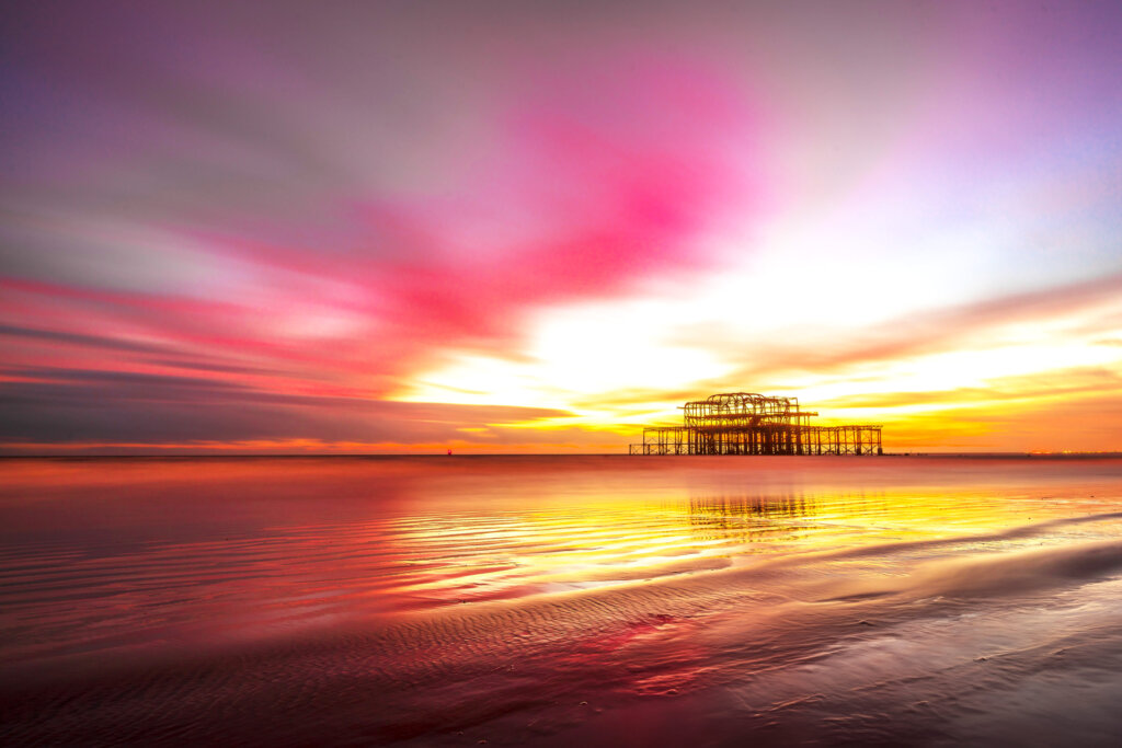 Vibrant Brighton Sea coastal sunset painting the sky in warm hues, casting a serene glow over the horizon - a breathtaking moment captured by Brighton Gallery.