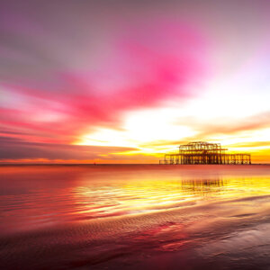 Vibrant Brighton Sea coastal sunset painting the sky in warm hues, casting a serene glow over the horizon - a breathtaking moment captured by Brighton Gallery.