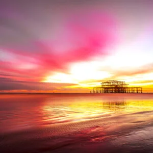 Vibrant Brighton Sea coastal sunset painting the sky in warm hues, casting a serene glow over the horizon - a breathtaking moment captured by Brighton Gallery.