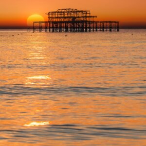 Stunning sunset over Brighton beach, showcasing the vibrant colors of the sky - a masterpiece of Brighton photography.