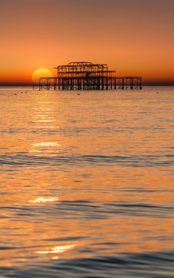 Stunning sunset over Brighton beach, showcasing the vibrant colors of the sky - a masterpiece of Brighton photography.